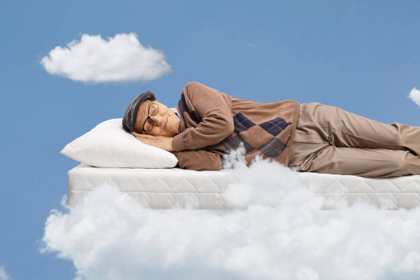 istock Elderly man sleeping on a matress and floating in a sky 1489906433