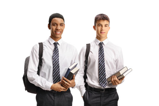 Male students in school uniforms holding books isolated on white background