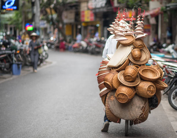 Vietnamese woman selling tropical fruits, old town in Hoi An city, Vietnam. Hoi An is situated on the east coast of Vietnam. Its old town is a UNESCO World Heritage Site because of its historical buildings.