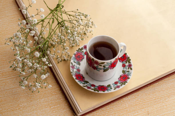 istock Cup of tea with flowers on a wooden table 1489915637
