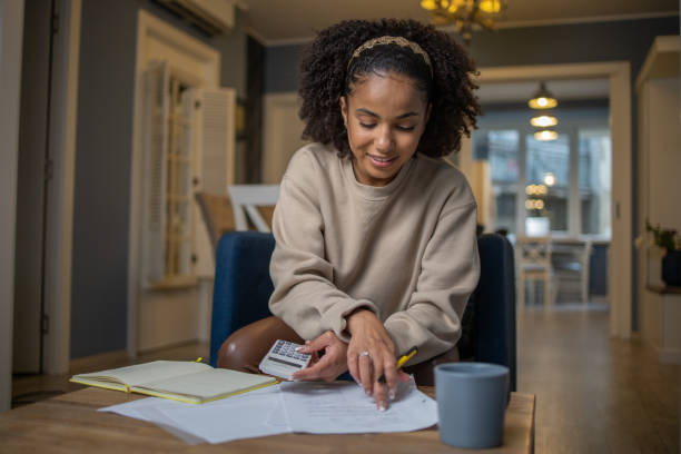 Doing taxes Woman comparing deals on the internet bank account stock pictures, royalty-free photos & images