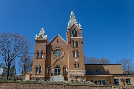 Henderson, Minnesota, USA - May 2, 2023: Daytime exterior view of St. Paul’s United Church of Christ, built in 1905, which was originally known as St. Paul's Evangelical Church. Constructed in the Gothic Cathedral style, the facade has two brickwork towers and a rose window.