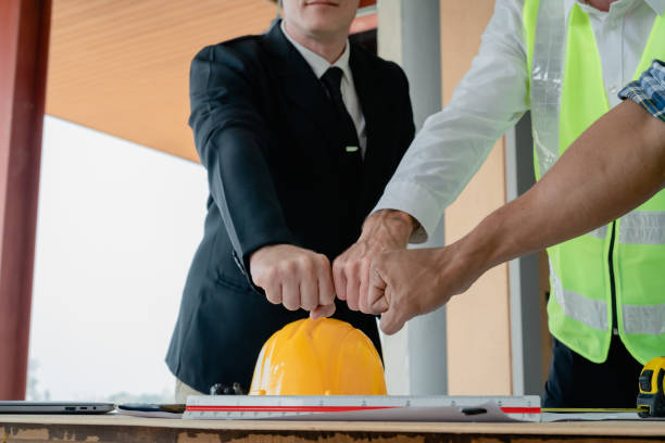 istock multi ethnic engineer brainstorming with deal and measuring for cost estimating on paperworks and floor plan drawings, contract and agreement concepts 1489929422
