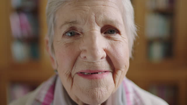 close up portrait of elderly caucasian woman in library smiling optimistic enjoying old age retirement