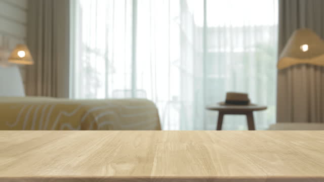 Empty wood table top and interior space of living room in the house background.