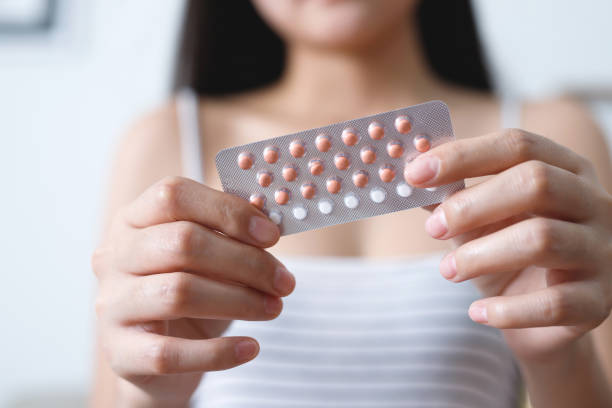 manos de mujer abriendo píldoras anticonceptivas en la mano. comiendo píldora anticonceptiva. la anticoncepción reduce el concepto de parto y embarazo. - pill human pregnancy capsule women fotografías e imágenes de stock