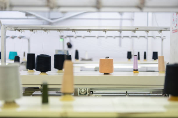 istock spool of thread for garment production Lined up in different colors in a sewing industry There was a weaving machine working nearby. to wait for the production of clothes for the business 1489943953