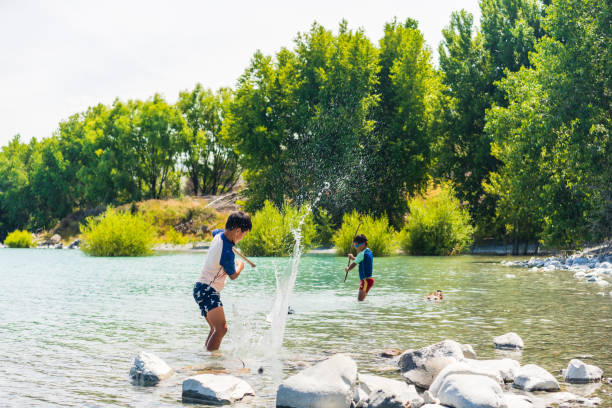 Carefree boy and girl having fun splashing water in field
