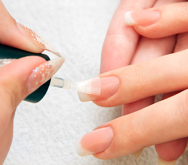 istock manicure making - female hands, covering of transparent enamel 148994792