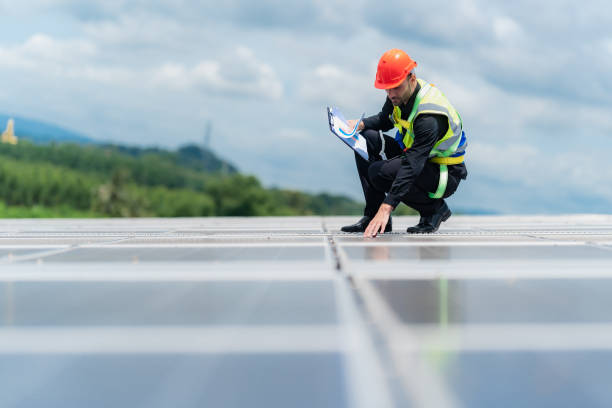 professional safety engineering man has service checking roof top of solar power construction under sunlight, engineering man working under the sunlight renewable the solar for eco energy environment. stock photo