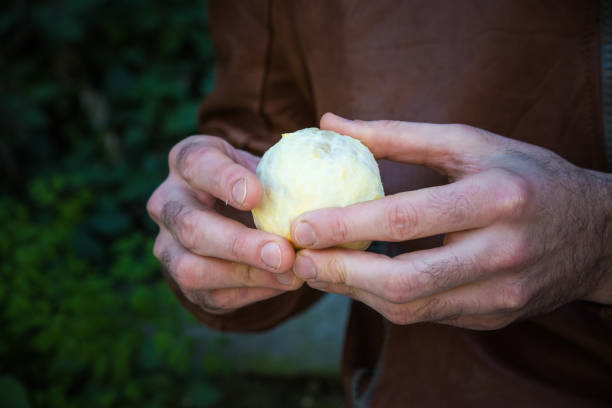 istock man holds in hands peeled round orange fruit 1489949273