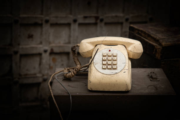 istock Old beige, antique phone  between old radios and papers 1489950277
