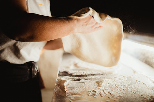 Prepping pizza dough in Italy at night with flour