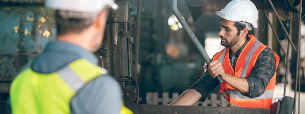 istock Teamwork men in construction site, Two civil engineer or professional foreman in safety helmet hard hat using blueprint in digital tablet working while standing at industrial factory, teamwork concept 1489960364