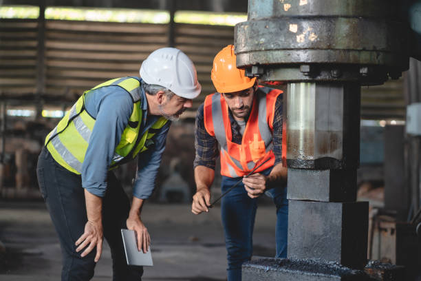 istock professional technician engineer with safety helmet hard hat working in industrial manufacturing factory, men at work to checking equipment of machinery production technology or construction operating 1489963734