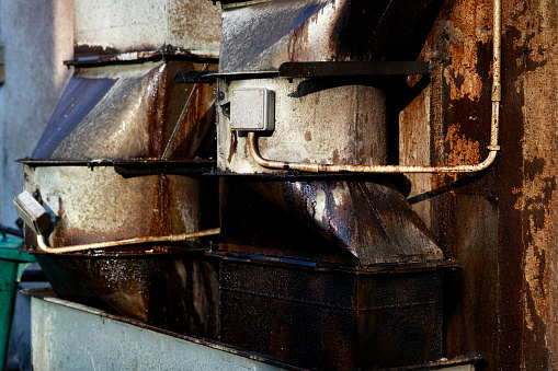 Stains and dirty attached to the commercial kitchen hood exhaust, located at the back lane of the restaurant.