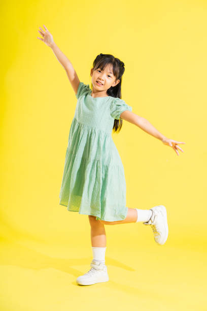 istock happy smiling asian girl on yellow background 1489966085