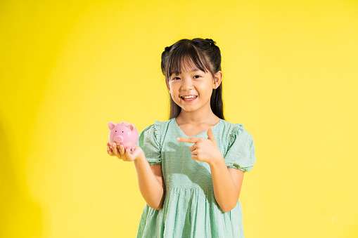 happy smiling asian girl on yellow background