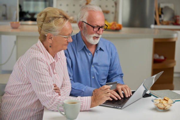 istock Excited and happy elderly couple shopping online from home using computer, smartphone and credit card. Modern technologies and retirement concept. 1489971397