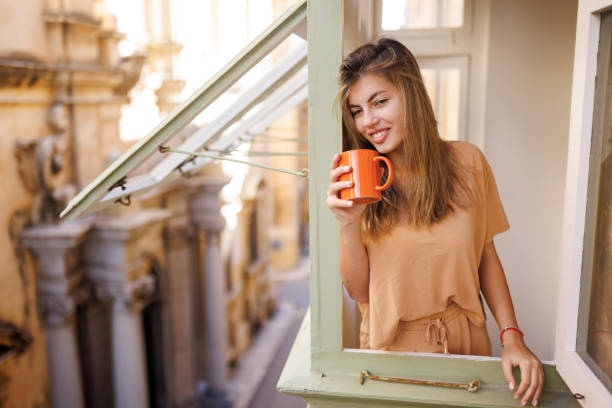 istock Woman drinking coffee by the window 1489975703