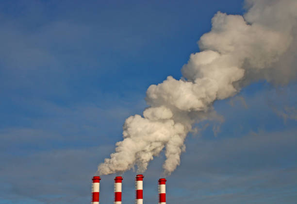 istock Industrial chimneys with white smoke against blue sky. 1489978437