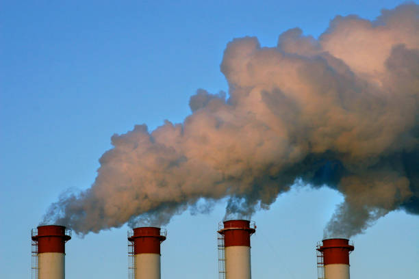 istock Industrial chimneys with white smoke against blue sky. 1489978606