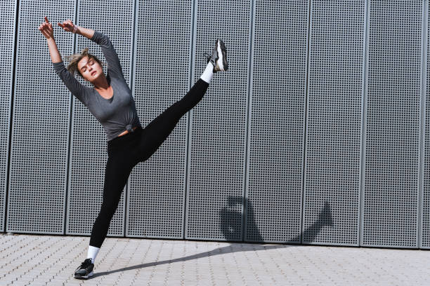 istock Expressive woman dancer performing against  background with modern steel panels 1489980096