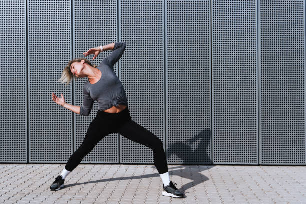 istock Expressive woman dancer performing against  background with modern steel panels 1489980125