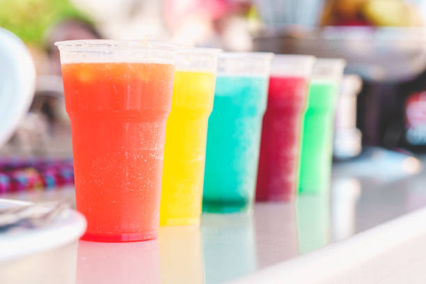 Vibrant array of Sicilian seltz and syrups based drinks in various flavors like mandarin, orange, green mandarin, mint, chinotto, and strawberry at a kiosk in Catania province.
