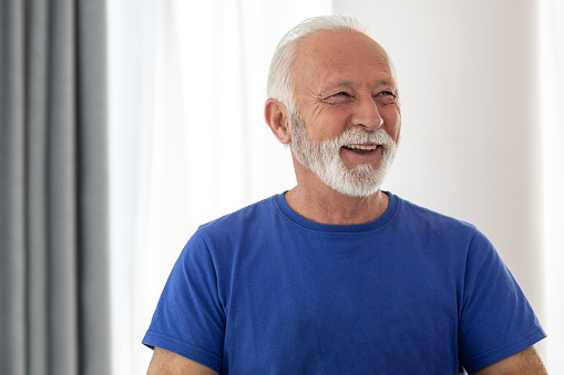 Portrait of cheerful elderly man who is looking away and laughing.