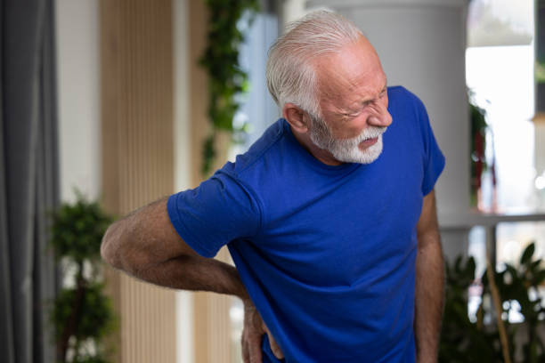 istock Elderly man holding hand on his lower back, suffering from osteoarthritis pain at home 1489982449
