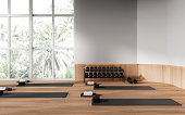 White and wooden gym interior with yoga mats