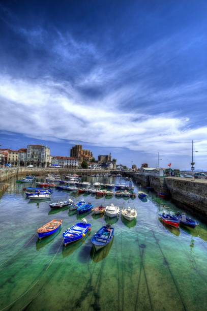 coloridas embarcaciones en el puerto de castro-urdiales frente a su iglesia fortaleza. cantabria, españa - harborage fotografías e imágenes de stock