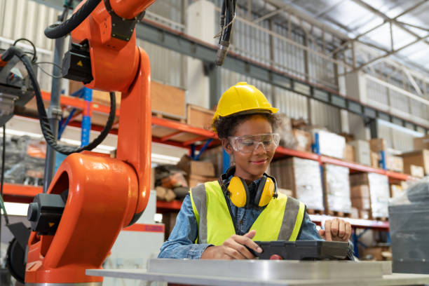 istock Young African American female engineer operating welding robot arm machine in warehouse factory.Professional technician automation robotic industrial 1489992124