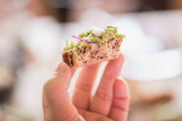 Hand holding guacamole sandwich, close up, selective focus