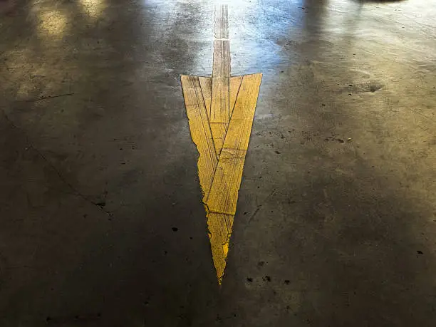 Yellow arrow sign and concrete floor