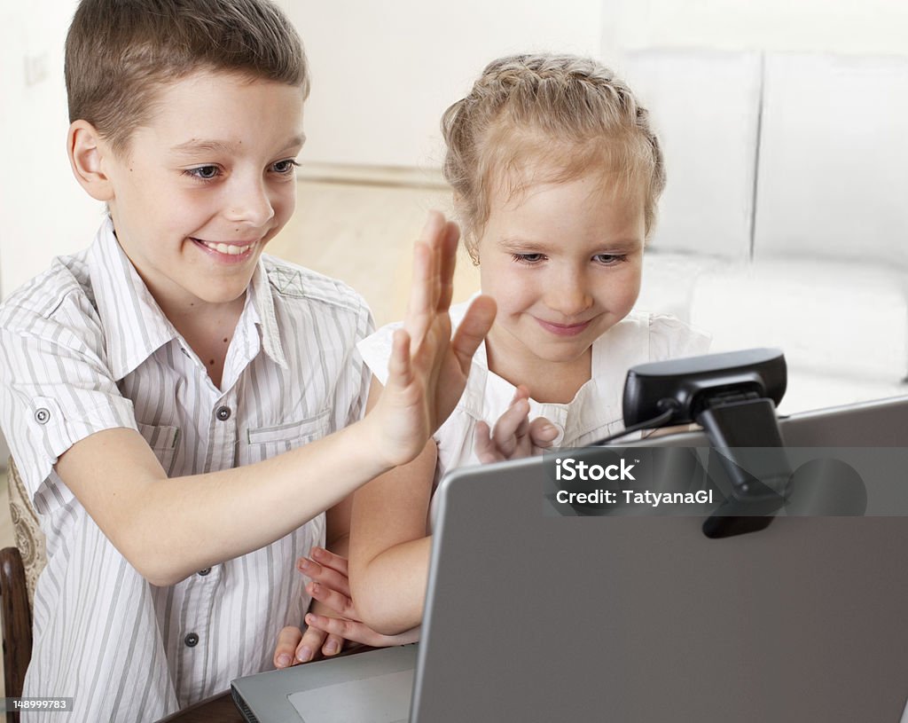 Children communicate with online Children communicate with online. Kids with laptop Child Stock Photo