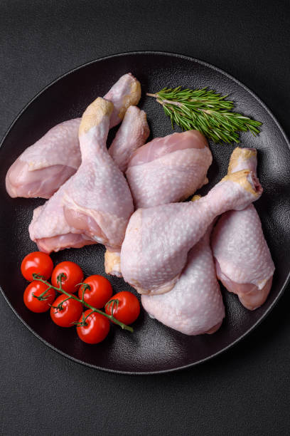 istock Raw chicken legs with salt, spices and herbs 1490001451