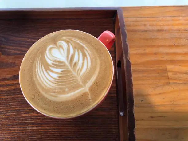 Photo of A latte with a wood grain table
