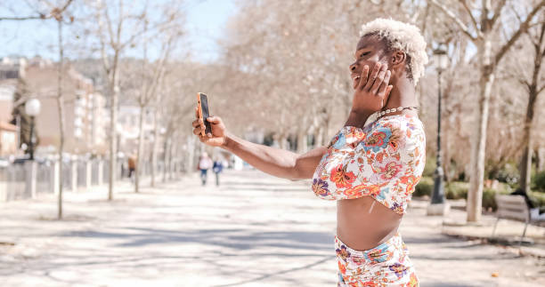 istock Transgender person posing while taking selfies with a mobile phone outdoors. 1490010746