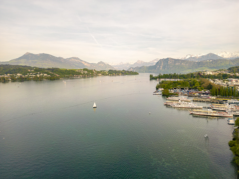 Montreux, VD / Switzerland - 31 May 2019: boats on the shores of Lake Geneva with great view of the Swiss Alps behind as seen from the Montreux Riviera