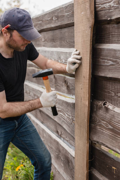 An adult man is engaged in carpentry work at a house construction site