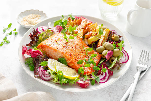 filete de salmón a la parrilla, papa frita y ensalada verde de verduras frescas - mediteranean cuisine fotografías e imágenes de stock