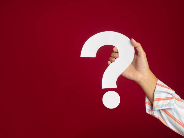istock Hand holding a white question mark against a red background 1490031859