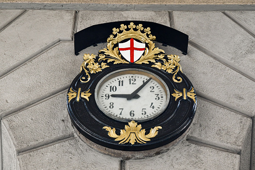 Genoa, Liguria, Italy - 10 23 2022: Close-up of an old street clock with the symbols of Genoa.