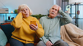 Senior man woman couple use smartphone surprised by bad news, fortune loss, fail, lottery results