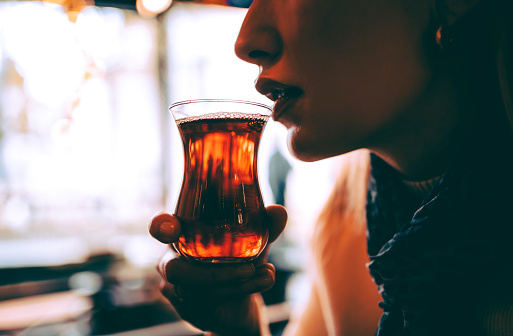Young woman drinking Turkish tea in a traditional teacup in Istanbul, Turkey