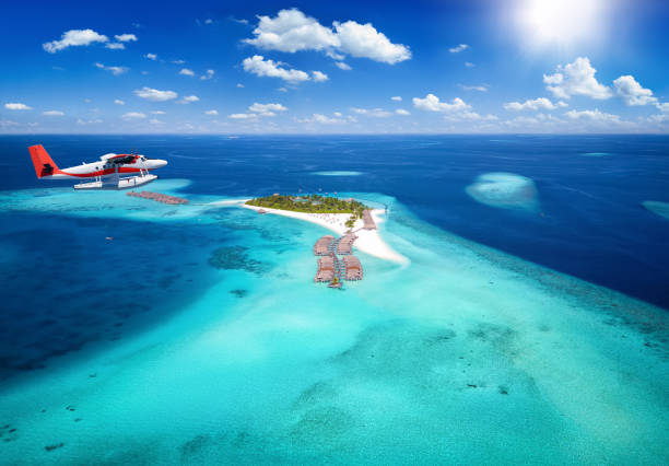 exotisches reisekonzept mit luftaufnahme eines wasserflugzeugs im anflug auf eine tropische paradiesinsel - malediven stock-fotos und bilder