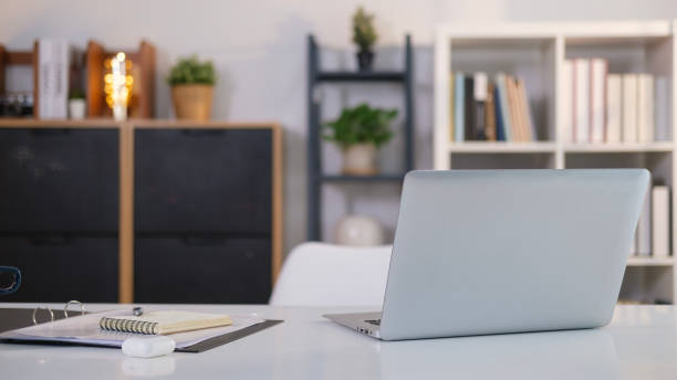 istock Home office interior with laptop computer and paperwork on white table. 1490065789