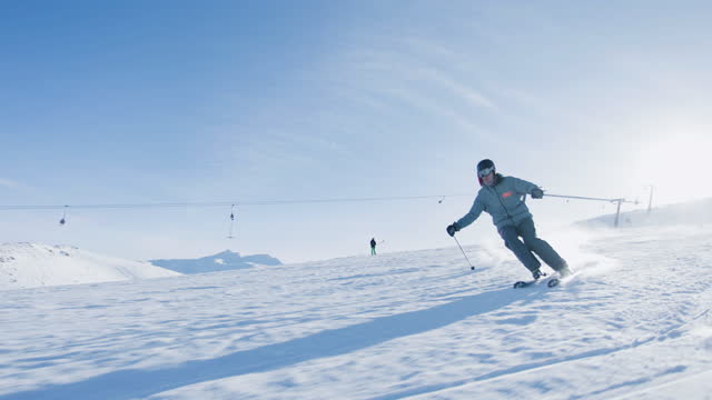 Experienced male skier skiing on slopes on a ski center. Recorded at 120 fps.